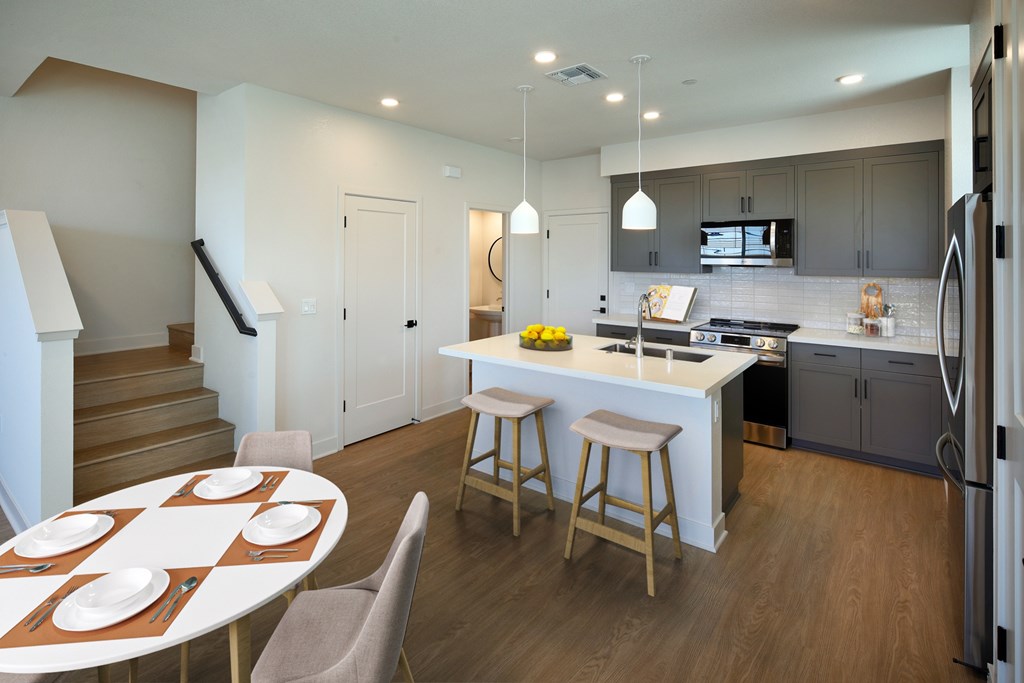 A modern kitchen with a dining table set for four.