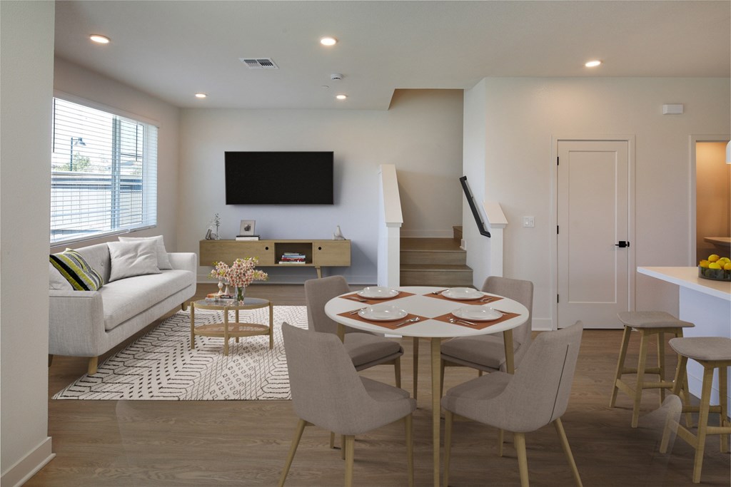 A modern living room with a white couch, a coffee table, and a television.