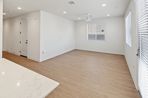 A spacious room with a marble table and wooden flooring.