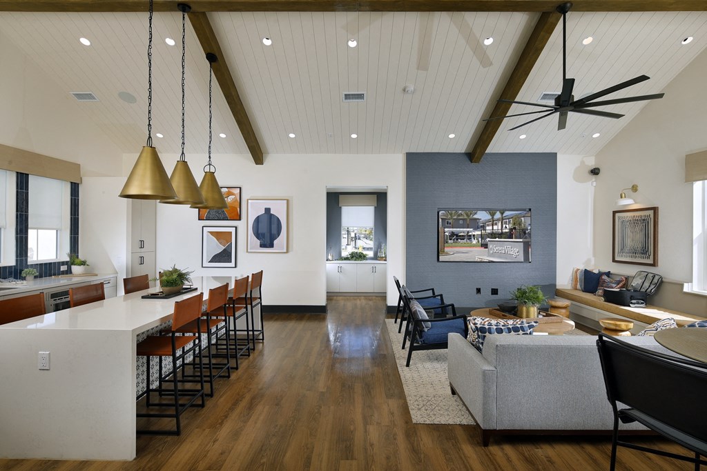 A modern open plan living and dining area with a kitchen island and bar stools.