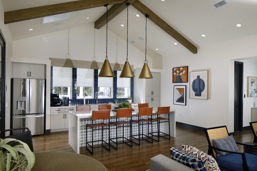 A modern kitchen with a bar area and a dining table.