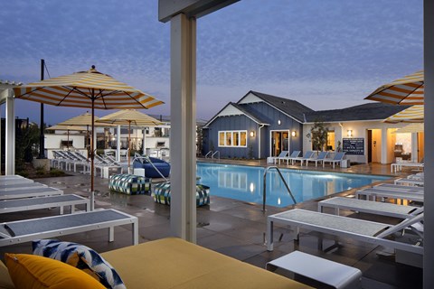 A poolside area with lounge chairs and umbrellas.
