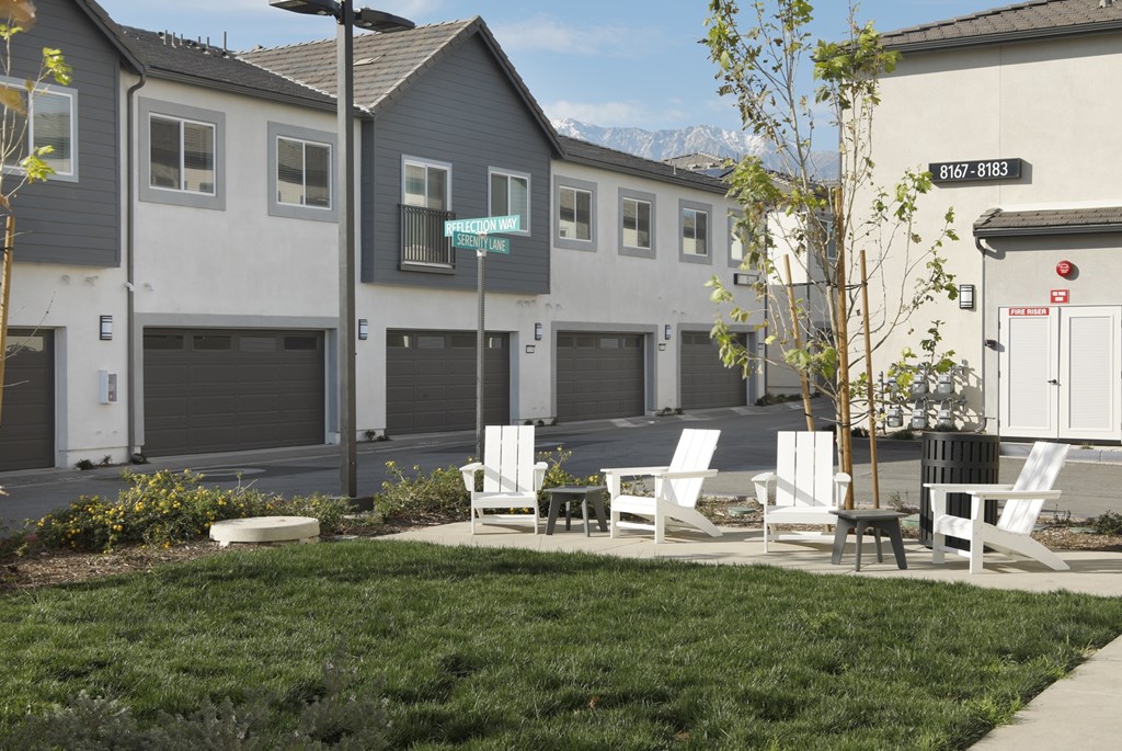 A row of houses with a green lawn in front.