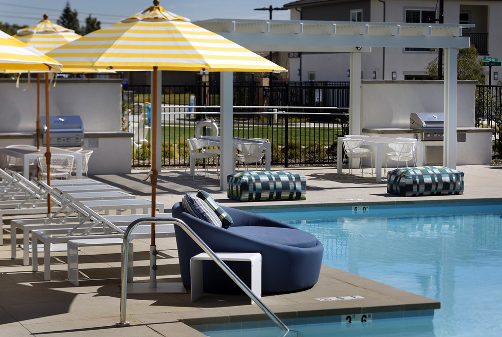 A poolside area with sun loungers and umbrellas.