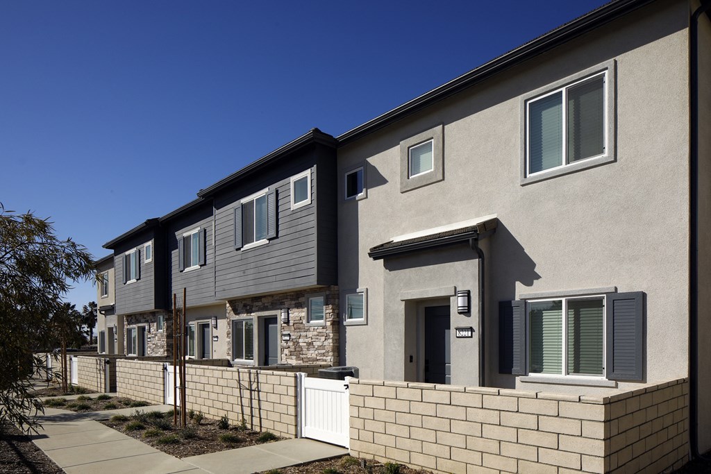 A row of houses with a clear blue sky above them.