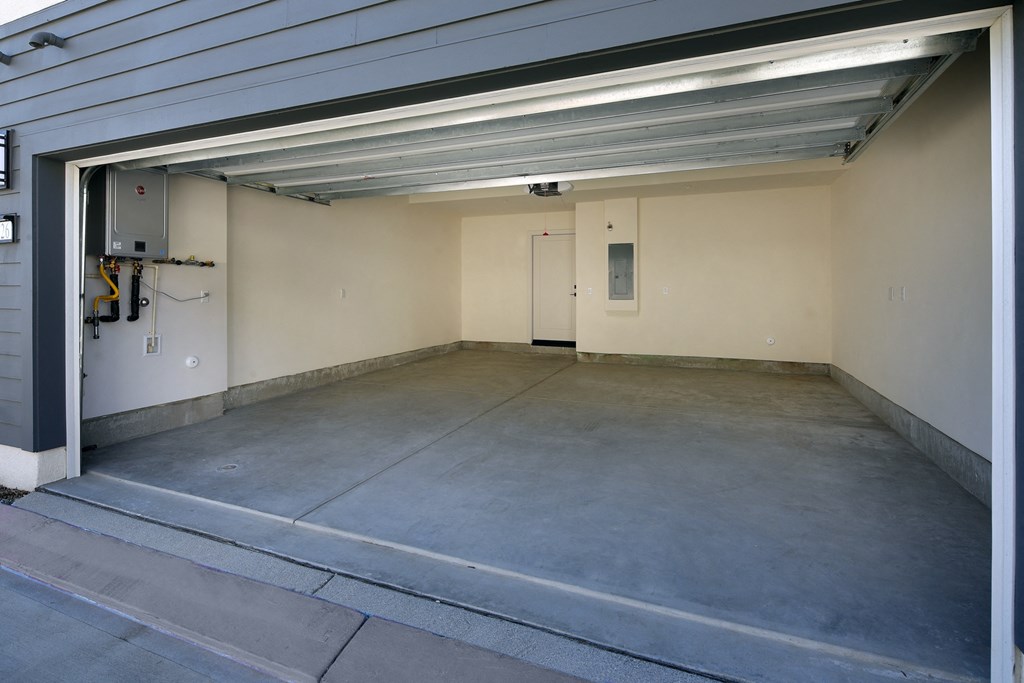 A garage with a concrete floor and a white door.