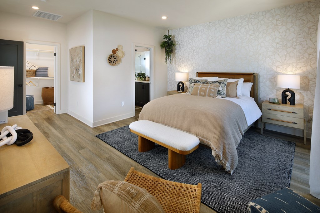 A bedroom with a bed, nightstand, and chair.