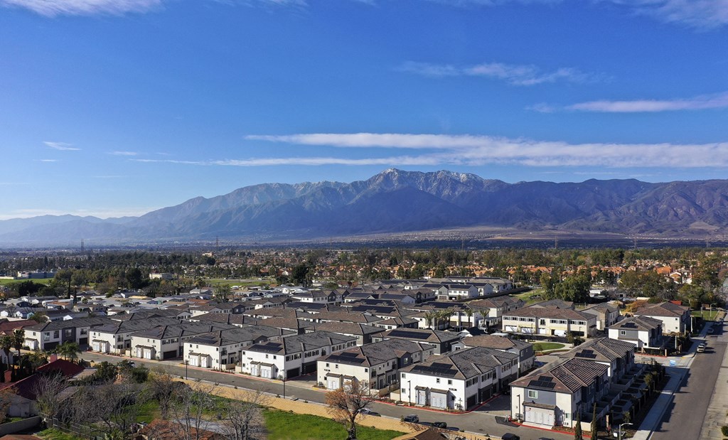 A residential area with houses and a mountain range in the background.