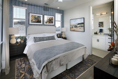 A bedroom with a large bed and a painting on the wall.