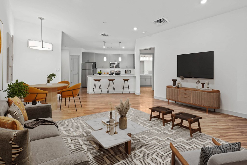 A modern living room with a grey sofa, wooden coffee table, and a television.