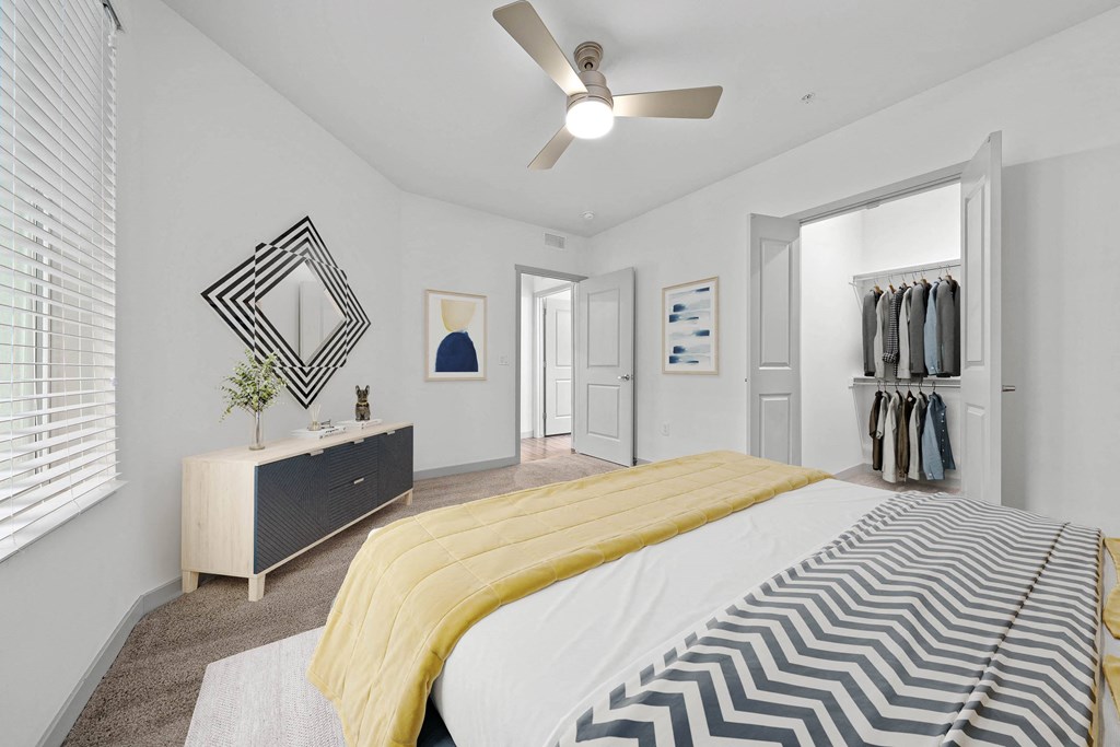 A bedroom with a bed, dresser, and mirror.