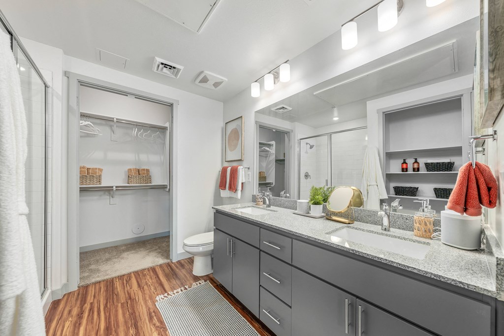 A bathroom with a white toilet, a sink, and a mirror.