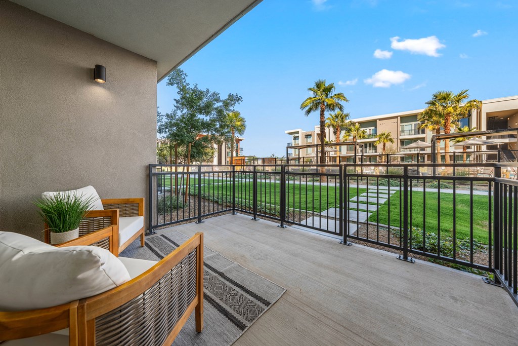 A balcony with a wooden bench and a black railing.