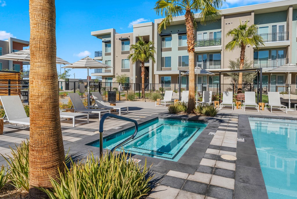 A pool surrounded by palm trees and chairs.