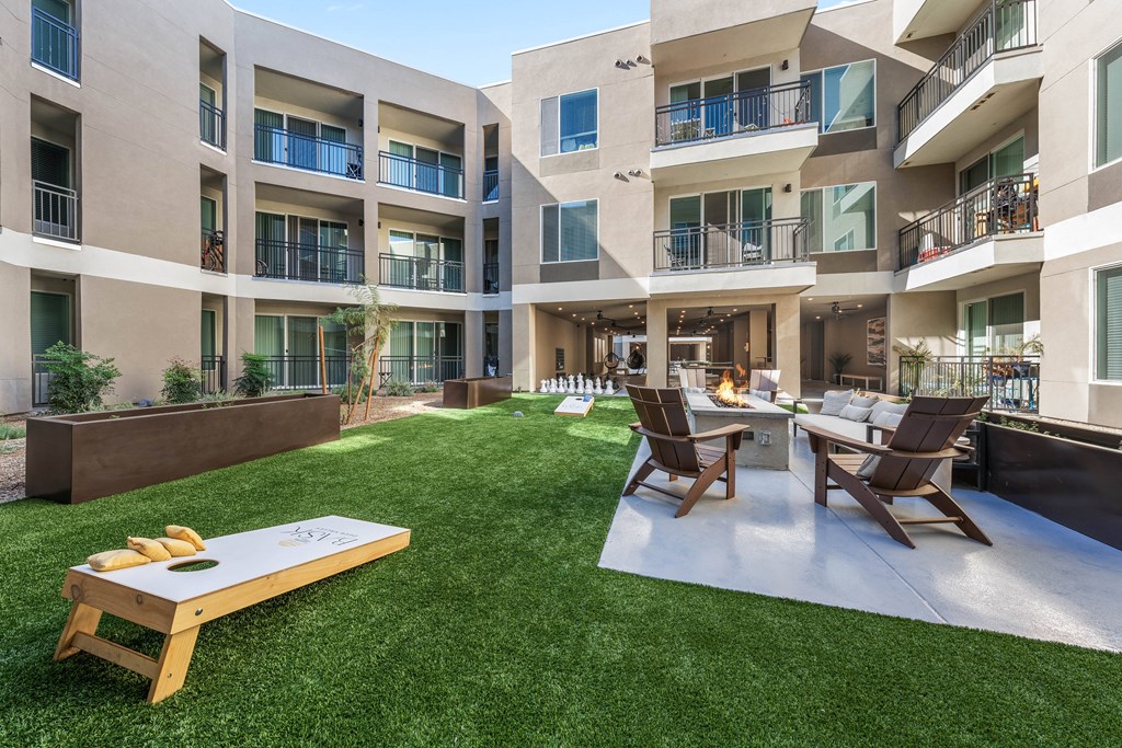 A patio with a table and chairs is surrounded by apartment buildings.