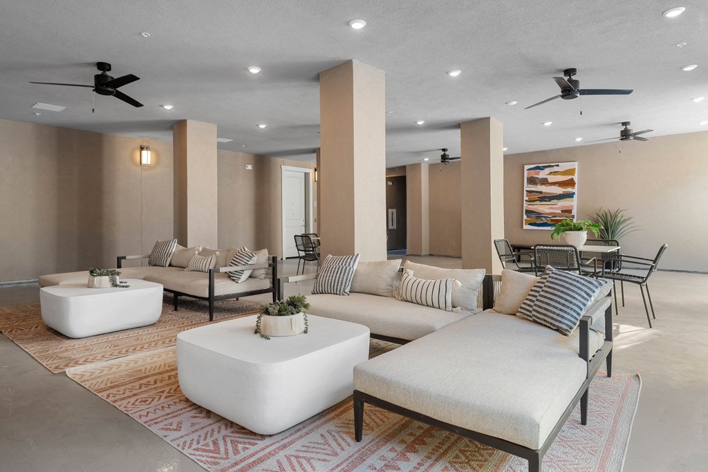 A living room with a white sofa, a white coffee table, and a rug with a geometric pattern.
