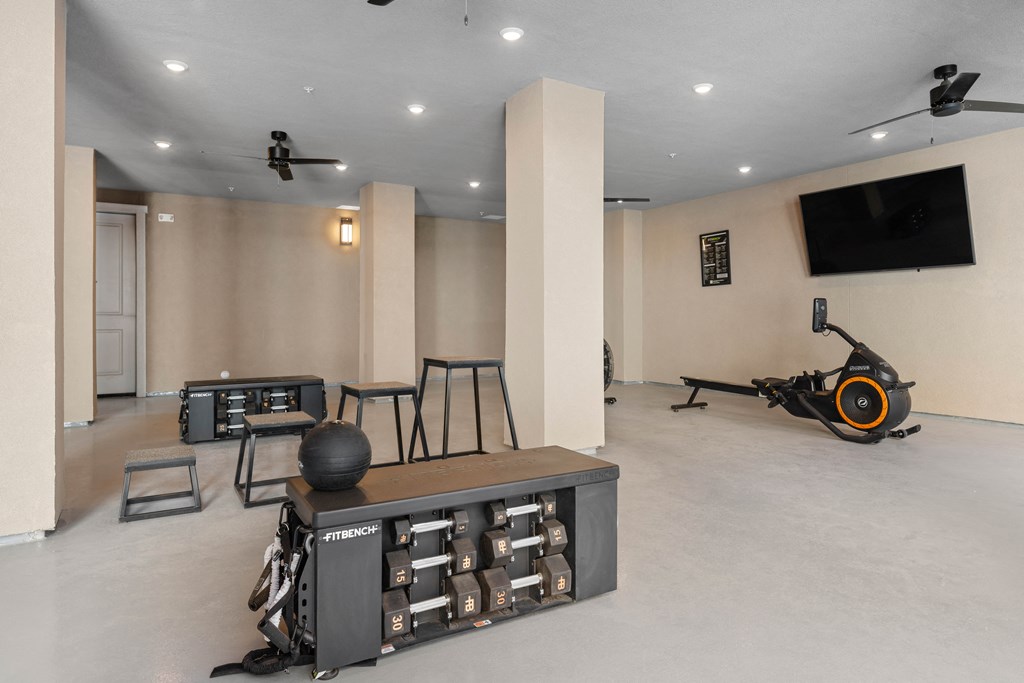 A room with a Fitness center and a TV on the wall.