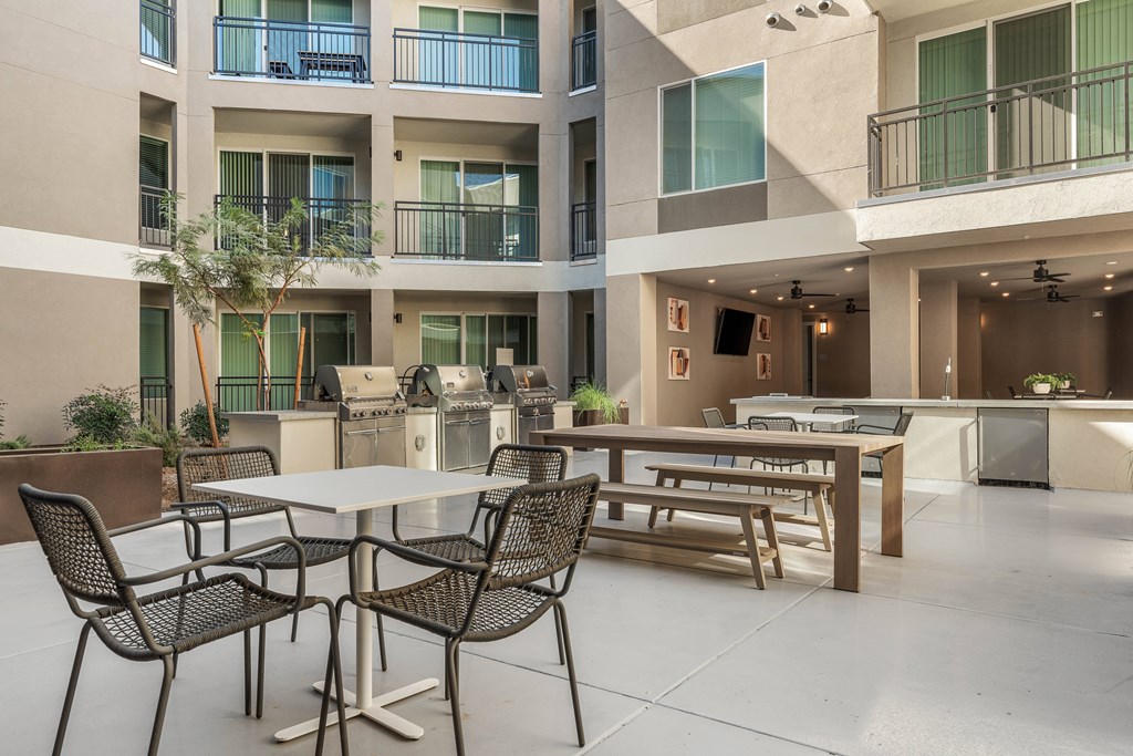 A patio with a table and chairs is surrounded by apartment buildings.