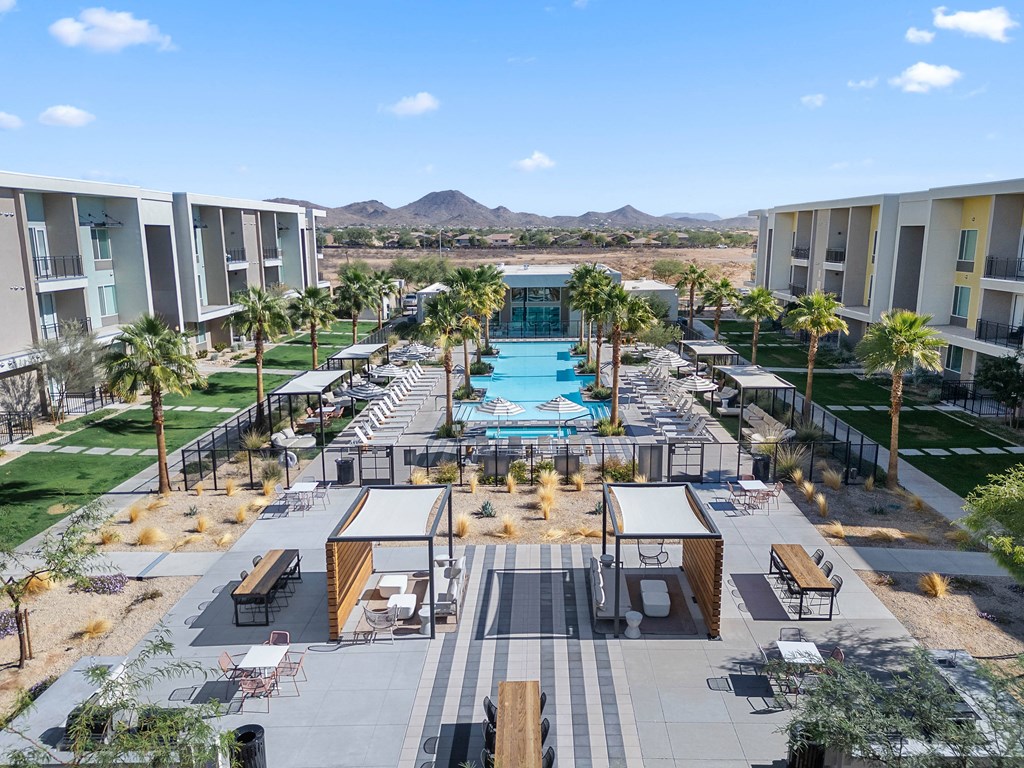 A pool surrounded by palm trees and apartment buildings.