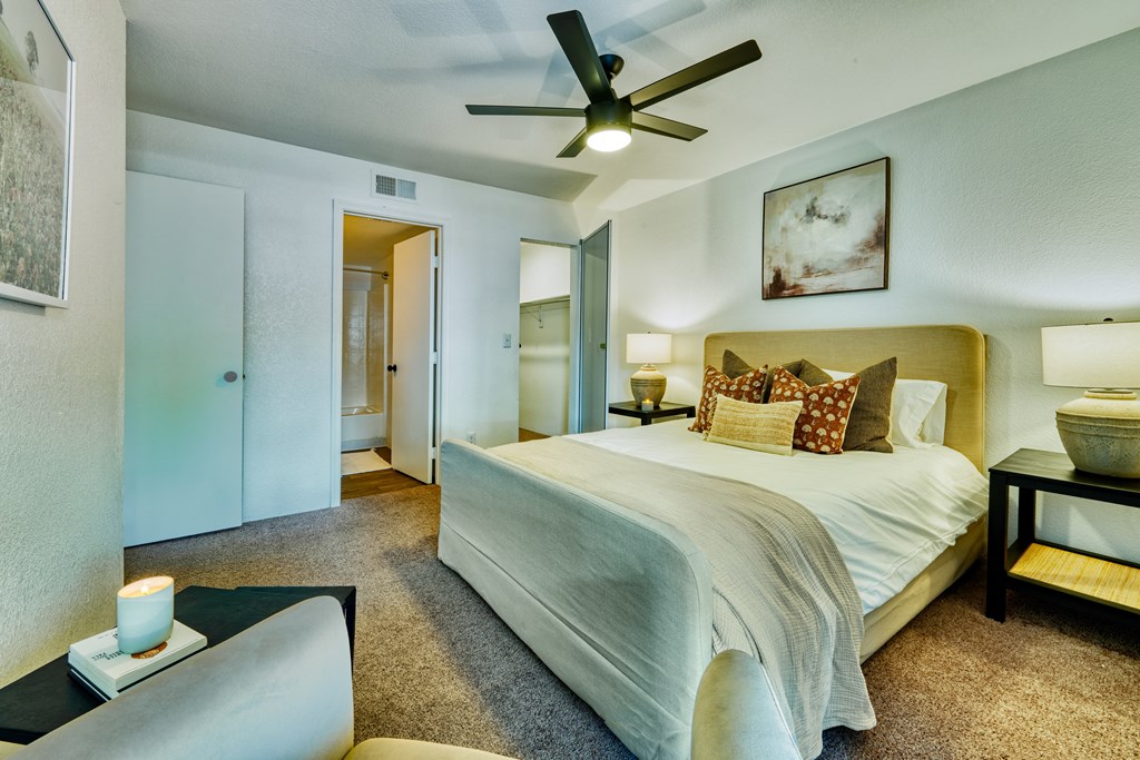 a bedroom with a large bed and a ceiling fan