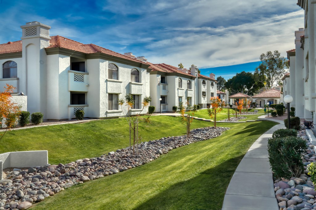 a row of houses with a sidewalk and grass