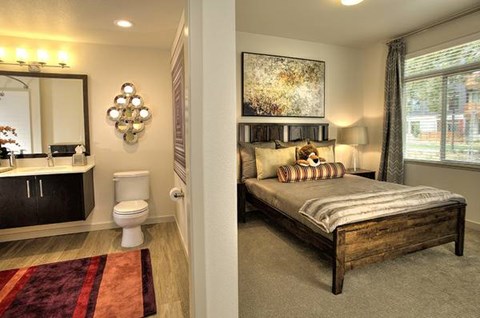 A bedroom with a bed, a toilet, and a mirror.
