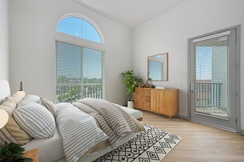 A bedroom with a large bed and a wooden cabinet.
