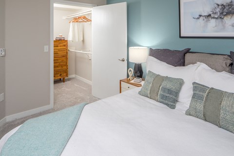 a bedroom with a large bed and a bathroom in the background