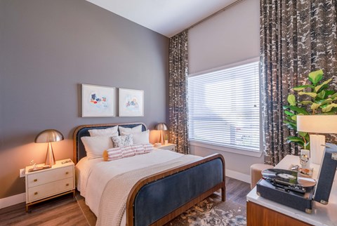 bedroom with bed, side table and large window