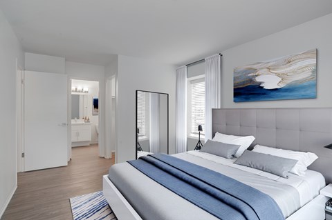 A bedroom with a large bed and a painting on the wall.