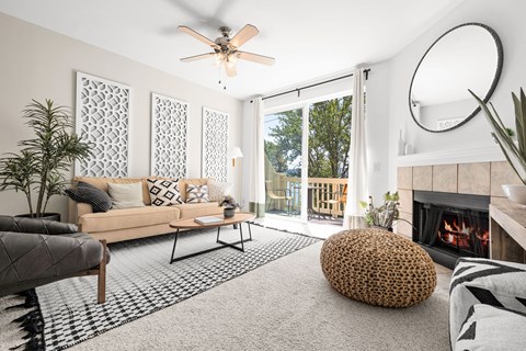 a living room with white walls and a sliding glass door leading to a balcony