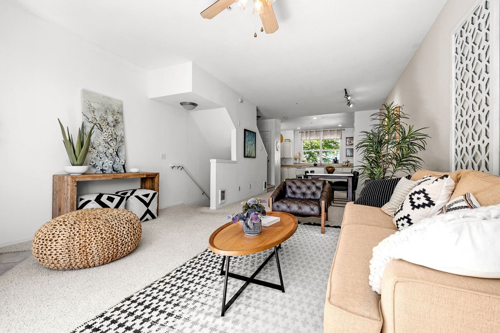 a living room with a beige couch and a black and white rug