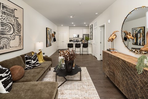 A living room with a brown couch and a large abstract painting on the wall.