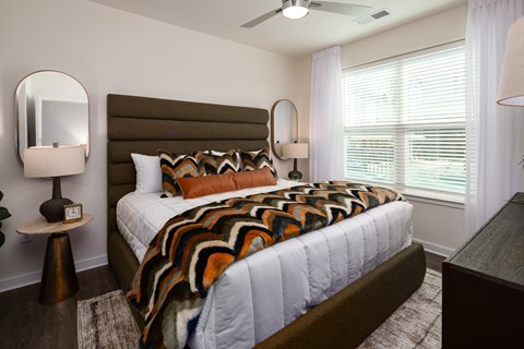 A bedroom with a large bed and a brown headboard.