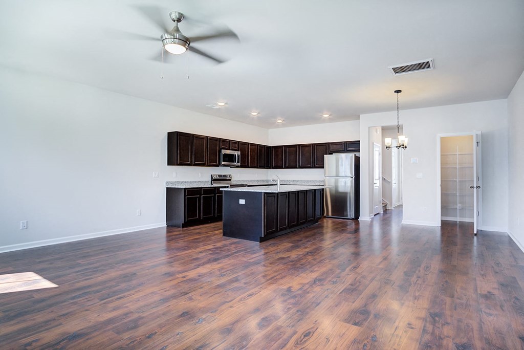 a kitchen and living room with hardwood floors and a ceiling fan at Berkeley Homes, South Carolina