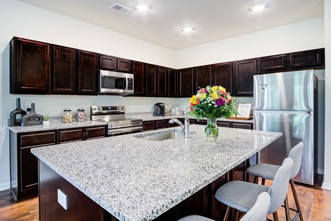 a kitchen with a marble counter top and a island with flowers