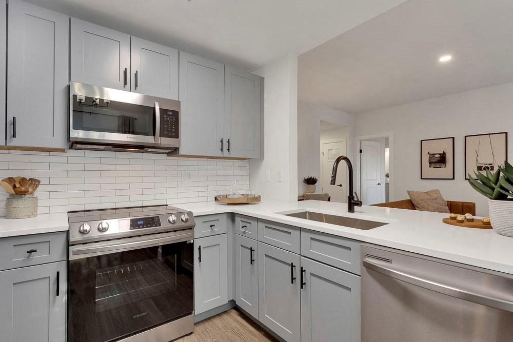 A modern kitchen with a stainless steel oven and microwave.