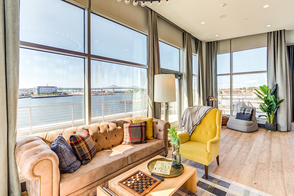 Shared community lounge with a yellow chair and a brown leather couch overlooking the ocean