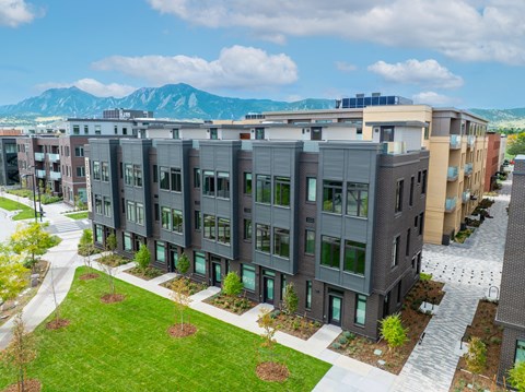 A modern apartment complex with a mountain in the background.