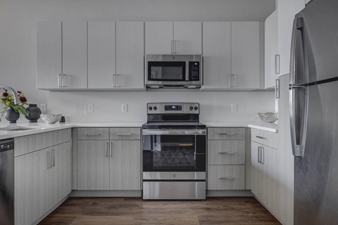 a kitchen with white cabinets and stainless steel appliances