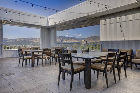 a terrace with tables and chairs and a view of mountains