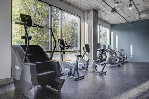 a gym with cardio machines and a treadmill