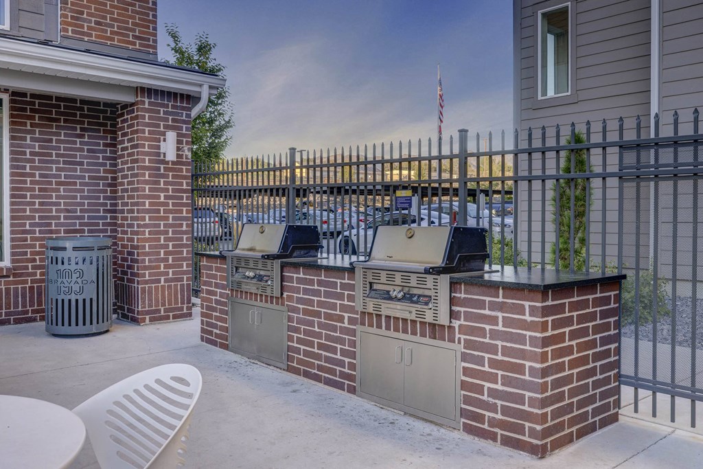 a covered patio with a grill and a bar with chairs
