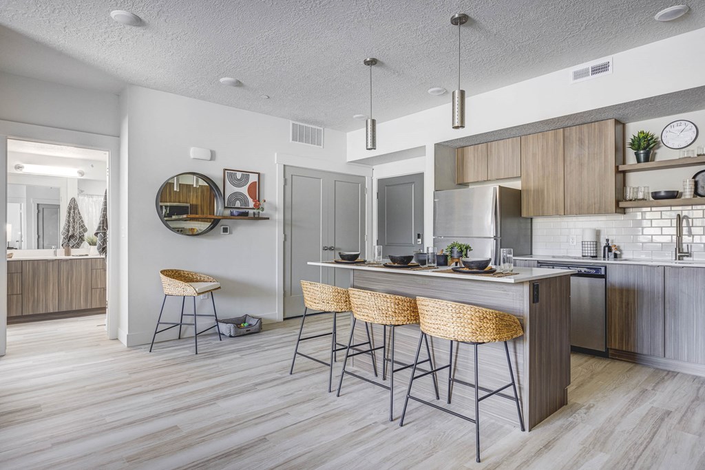 Kitchen with counter-height island, wood tone flooring, and designed furnishings