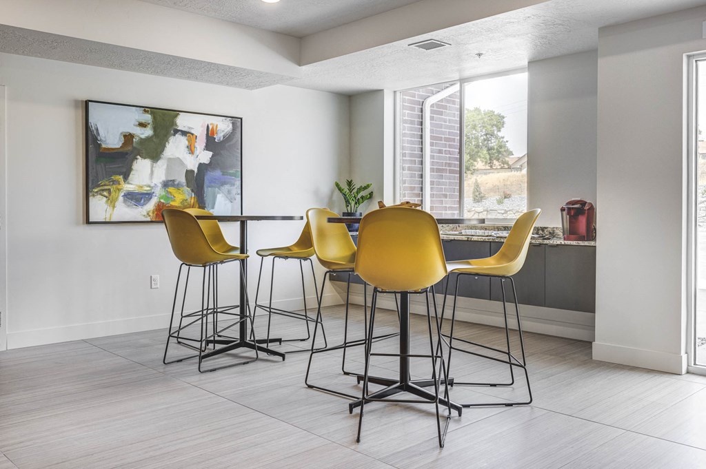 High-top tables with yellow chairs and art-work