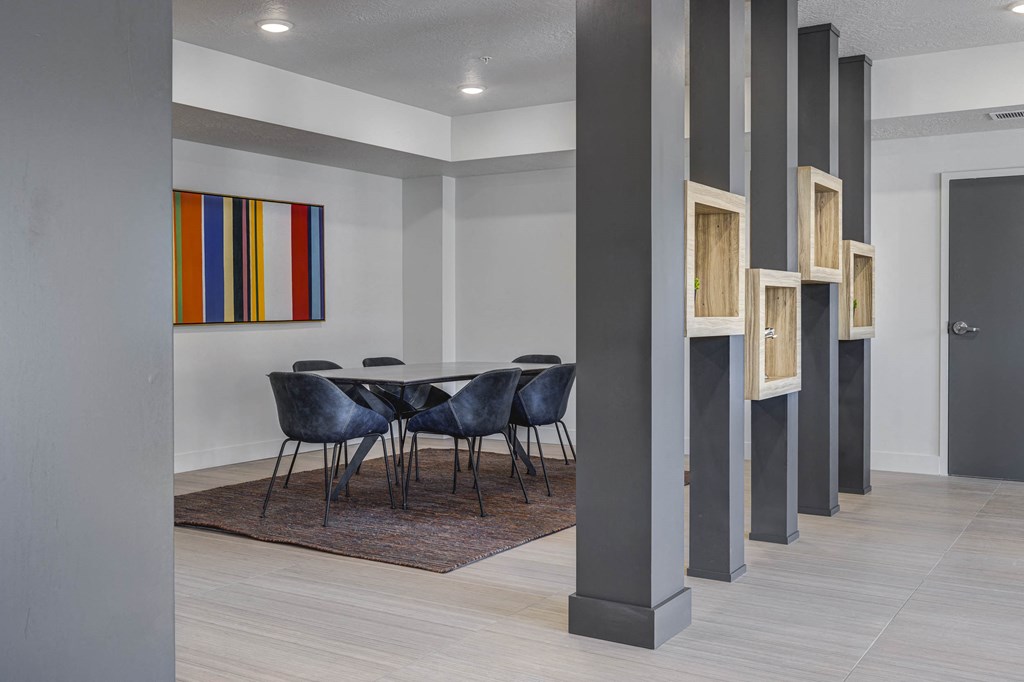 Meeting table with chairs in room behind gray beams