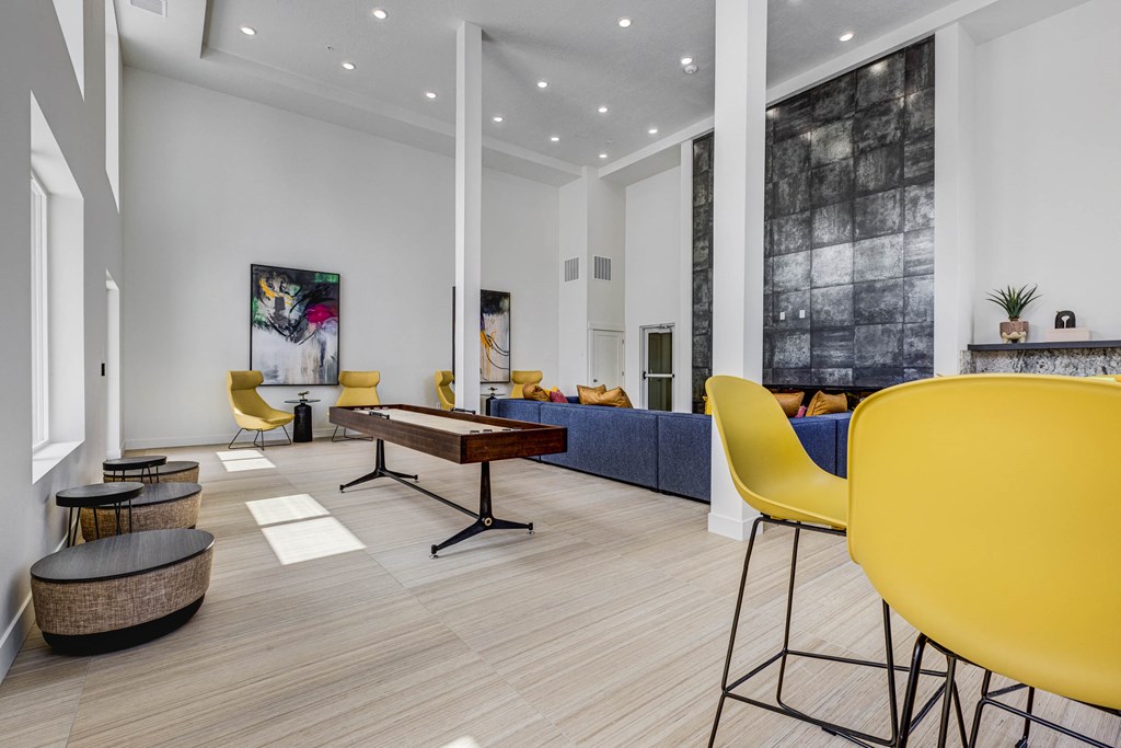 Large room with sitting areas, wood tone floors, and shuffle board