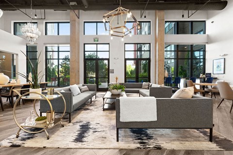 a living room with couches and chairs and large windows