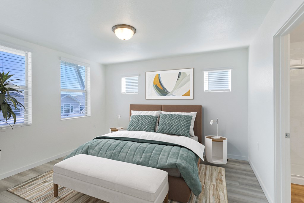 a bedroom with white walls and a bed with a green comforter