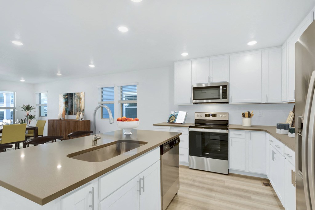 a kitchen with white cabinets and a large counter top